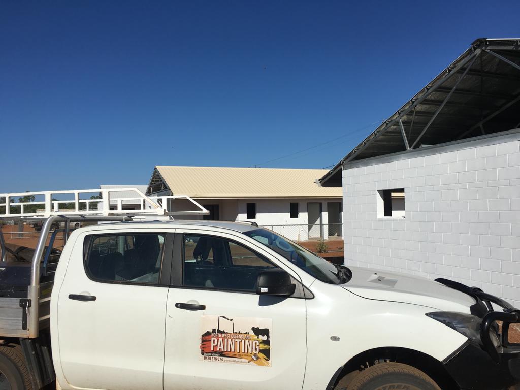 A white truck parked in front of a mining site building